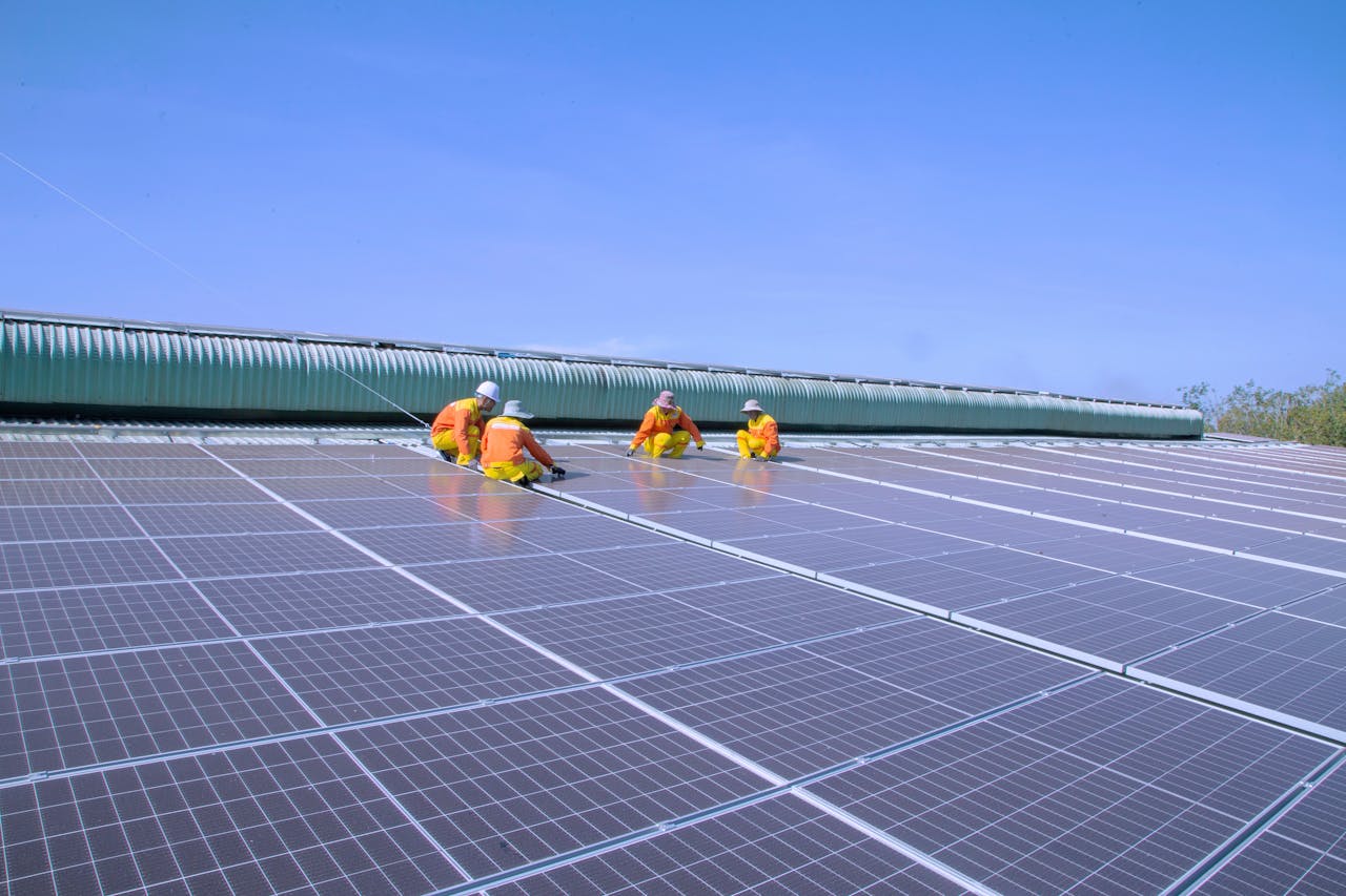 Workers installing solar panels on a sunny rooftop, emphasizing renewable energy and sustainability.